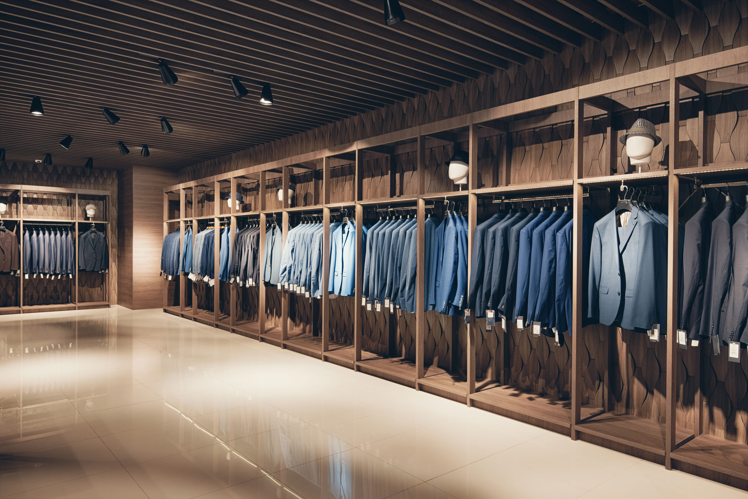 Interior of the business suit shop. Strict premium expensive suits hang in a row on hangers in large quantities